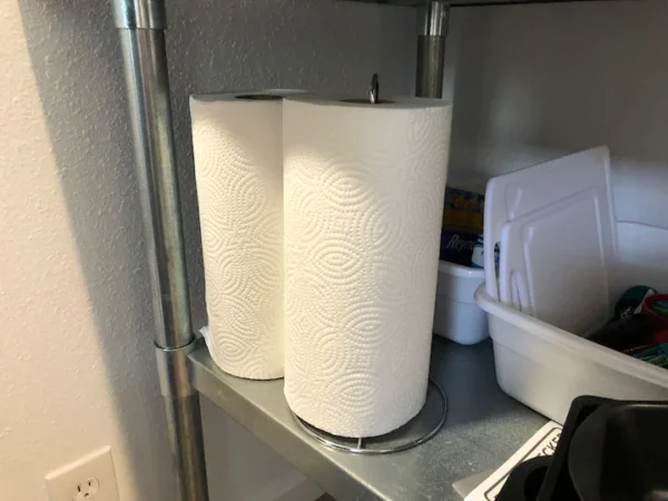 Two rolls of paper are on a shelf.