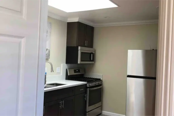 A kitchen with a refrigerator, stove and microwave.