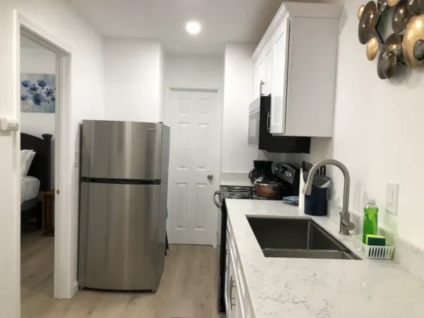 A kitchen with white walls and wooden floors.