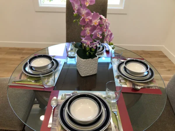 A table with four plates and a vase of flowers.