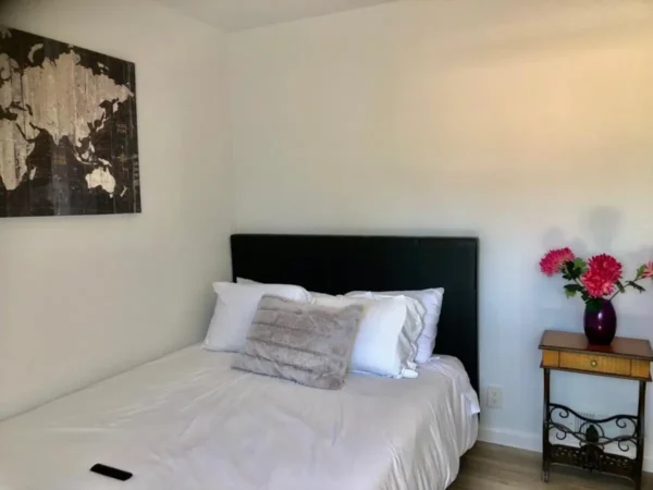 A bed room with a white bed and black headboard