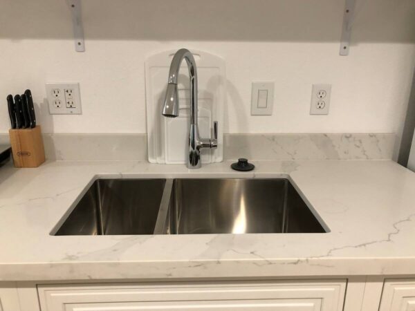 A kitchen sink with two sinks and a faucet.