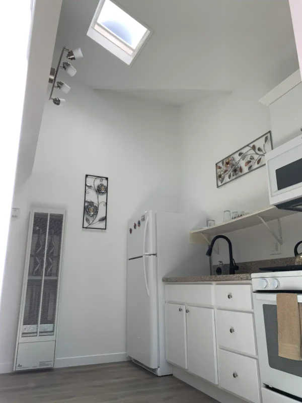 A kitchen with white cabinets and black appliances.