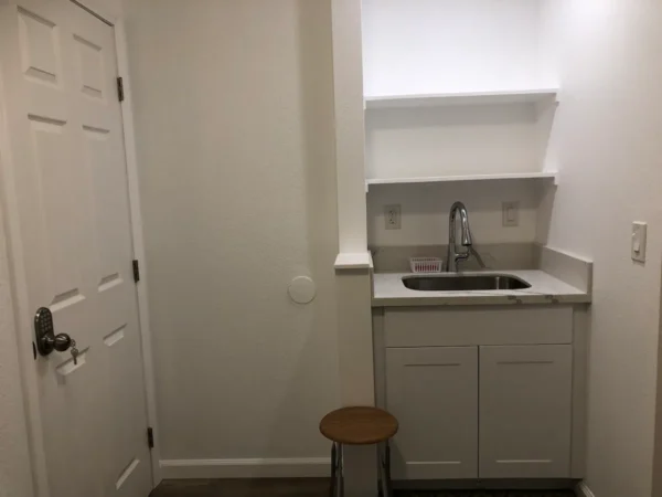 A small kitchen with white cabinets and a sink.