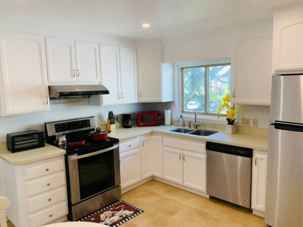 A kitchen with white cabinets and stainless steel appliances.