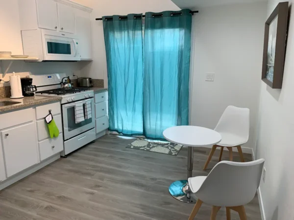 A kitchen with white cabinets and blue curtains.