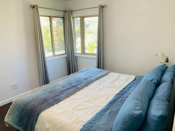 A bed room with a blue and white bedspread