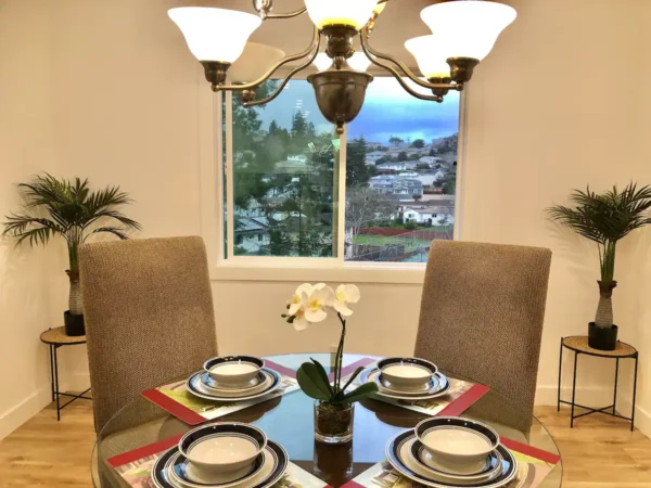 A dining room table with four chairs and plates.