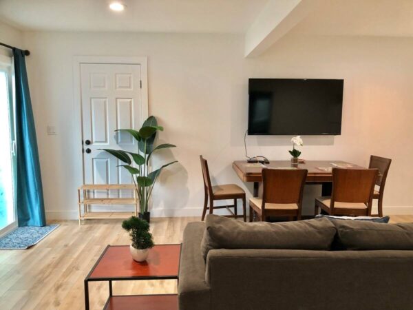 A living room with a couch, table and television.