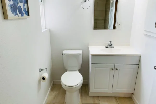 A bathroom with white walls and tile floors.