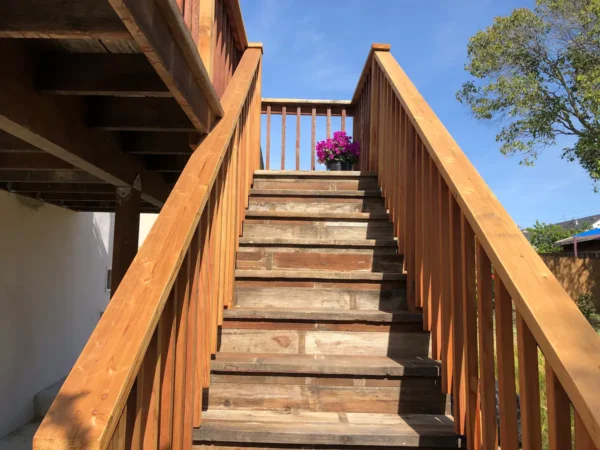 A wooden staircase with flowers on the top of it.