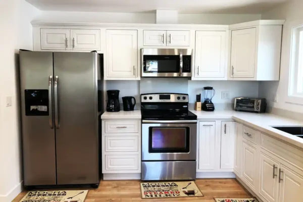 A kitchen with white cabinets and stainless steel appliances.