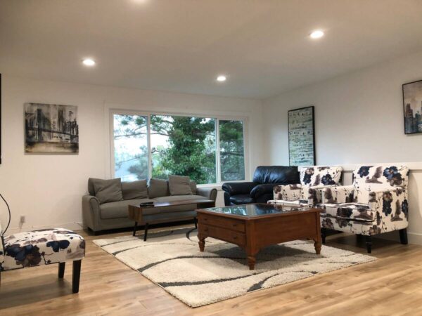 A living room with couches, chairs and tables.