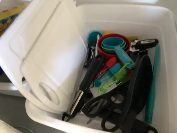 A white bin with some different colored items inside of it