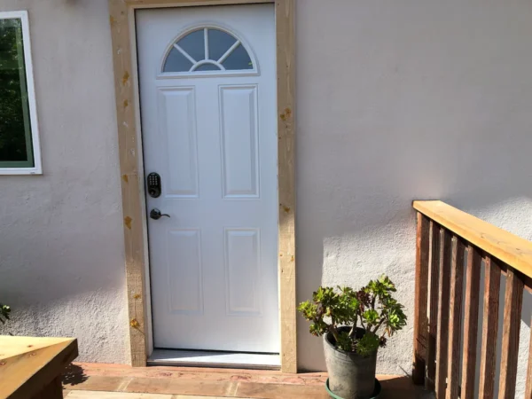 A white door with wood trim and a potted plant.