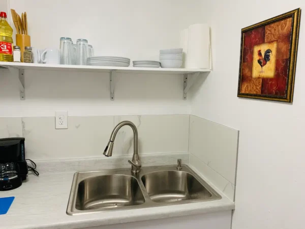 A kitchen sink with two sinks and a shelf above it.