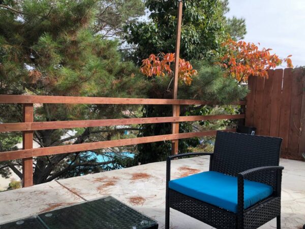 A blue chair and table on the patio.