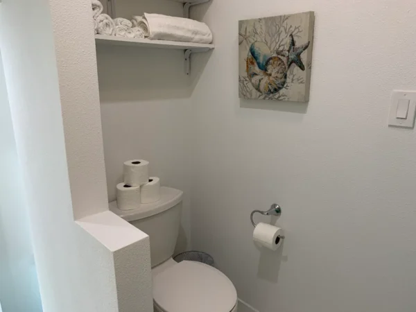 A bathroom with white walls and a toilet.