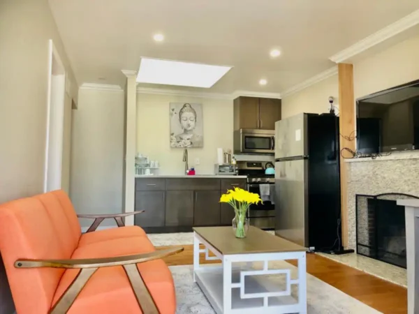 A living room with orange chairs and a black table