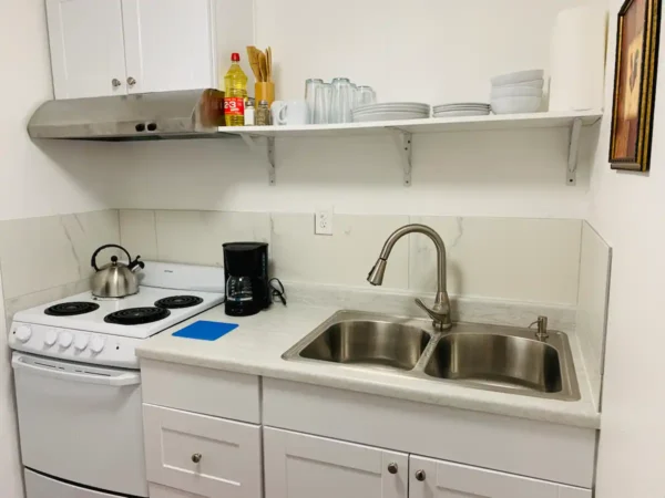 A kitchen with white cabinets and a sink.