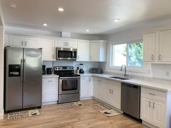 A kitchen with white cabinets and stainless steel appliances.