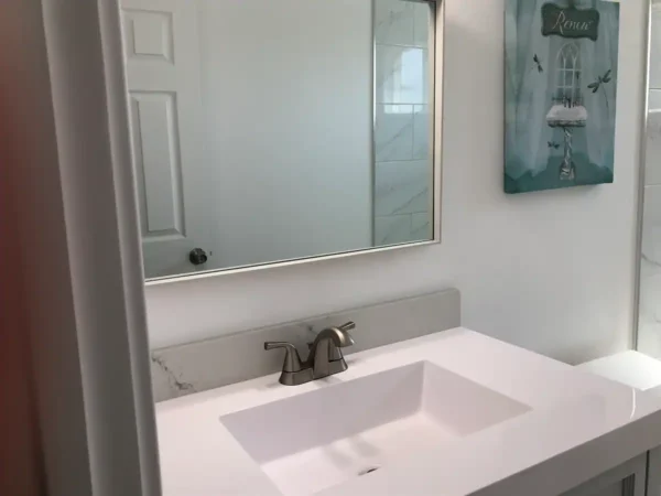 A bathroom with a sink and mirror in it