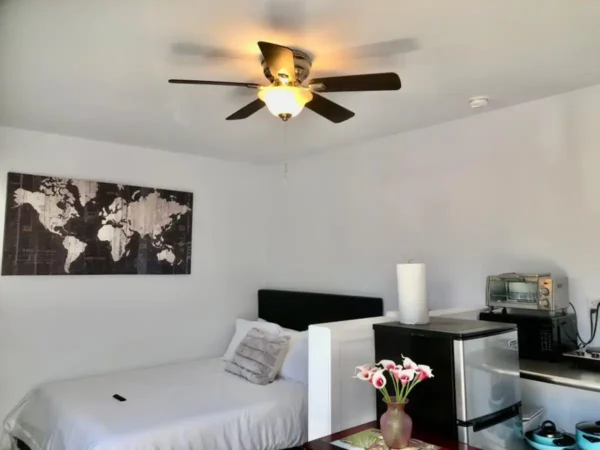 A bedroom with a bed and ceiling fan.