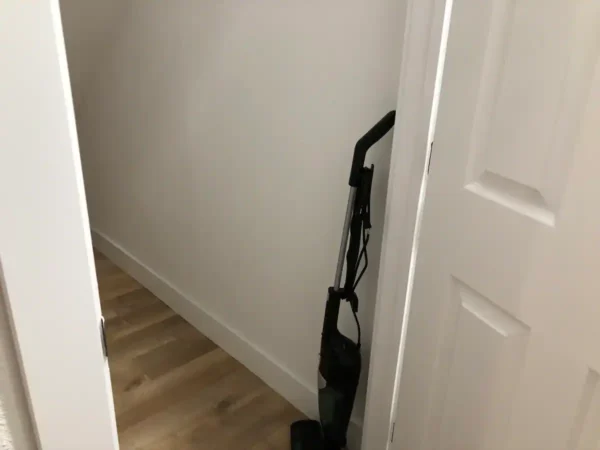 A vacuum is in the corner of a room.