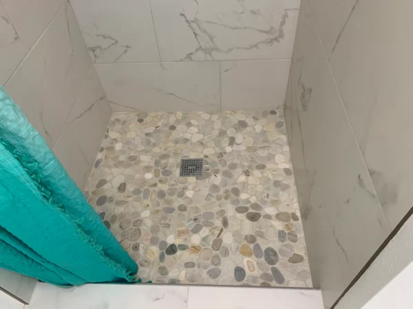 A bathroom with a shower and tiled floor