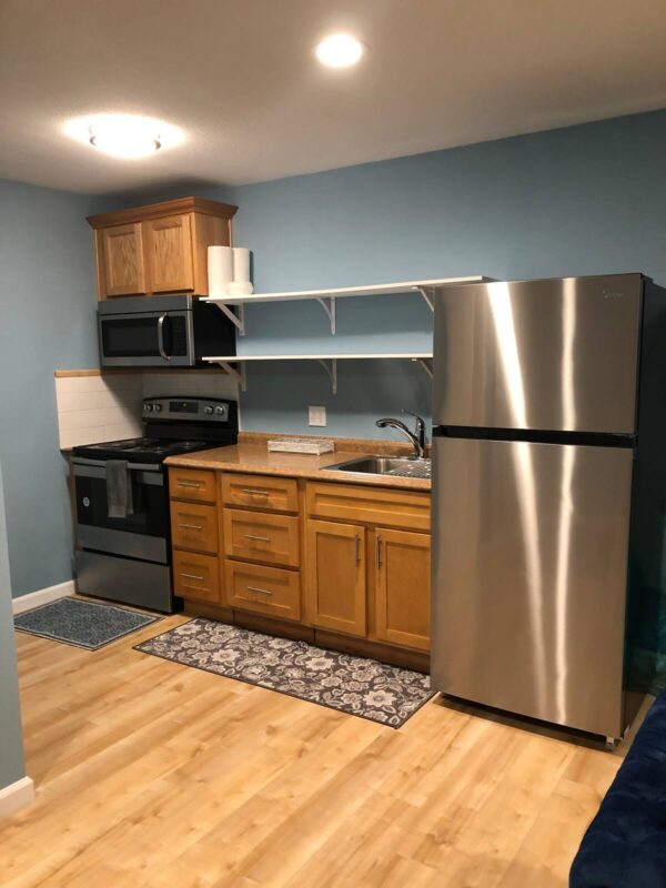 A kitchen with stainless steel appliances and wooden cabinets.