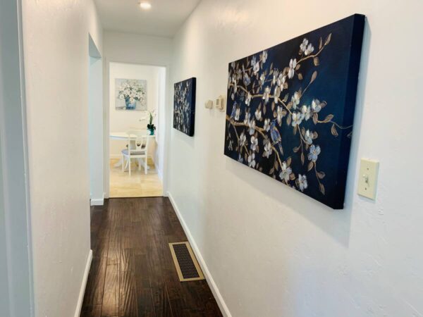 A hallway with two paintings on the wall.