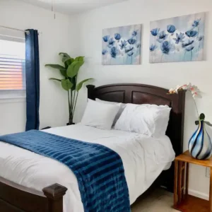 A bedroom with two pictures on the wall and a bed.