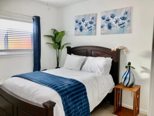 A bedroom with two pictures on the wall and a bed.