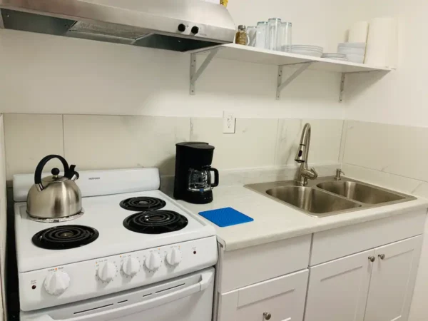 A kitchen with white cabinets and a stove.