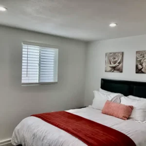 A bedroom with white walls and red accents.