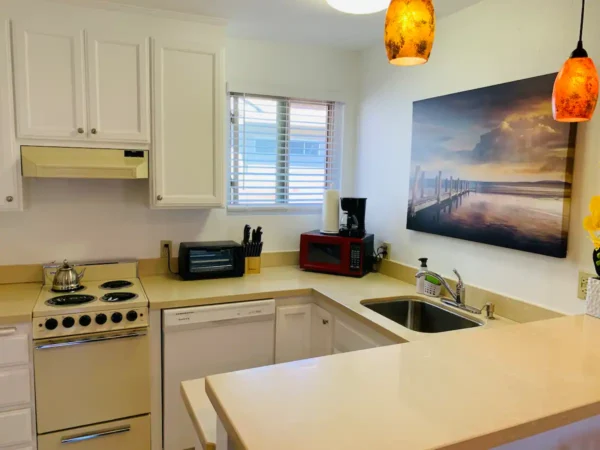 A kitchen with white cabinets and a sink.