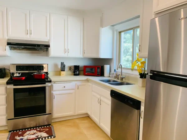 A kitchen with white cabinets and stainless steel appliances.