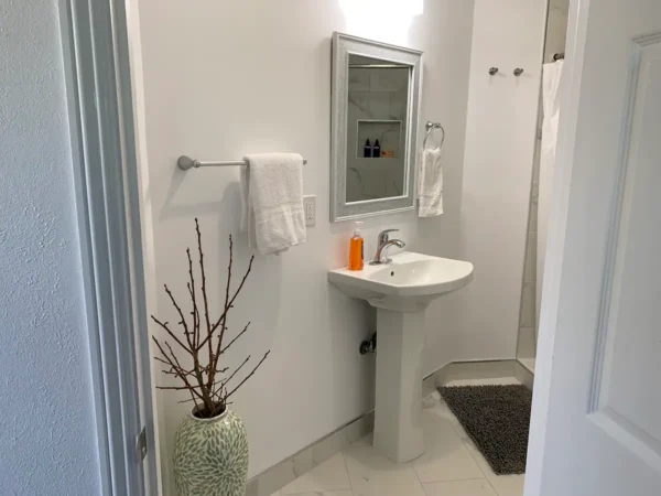 A bathroom with white walls and a sink.