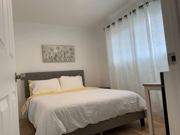 A bed room with a white bed and yellow sheets