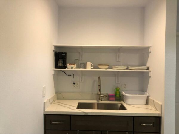 A kitchen with a sink and shelves in it