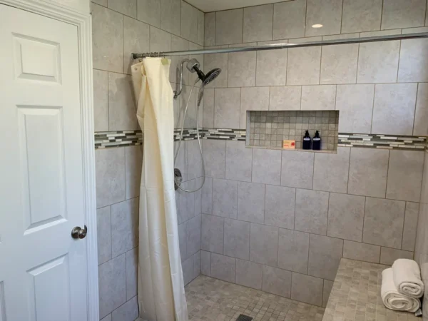 A bathroom with a shower and tiled walls.