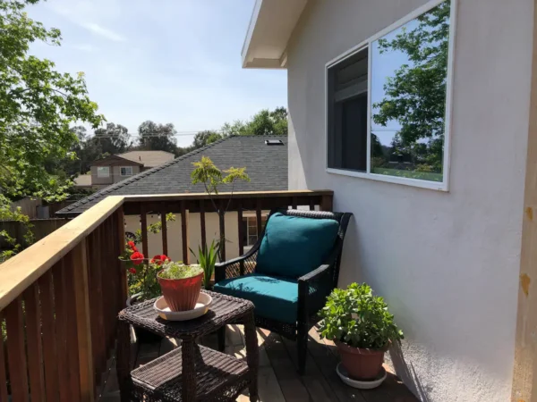 A small balcony with a chair and table