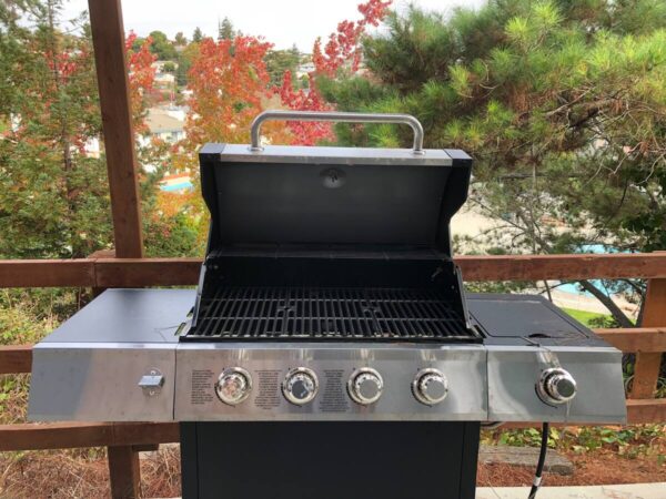 A grill that is sitting on top of a wooden deck.