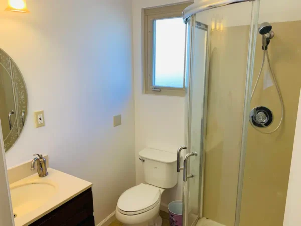 A bathroom with a toilet and shower stall.