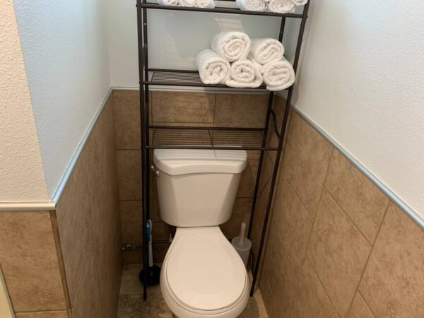 A toilet sitting in the corner of a bathroom next to towels.