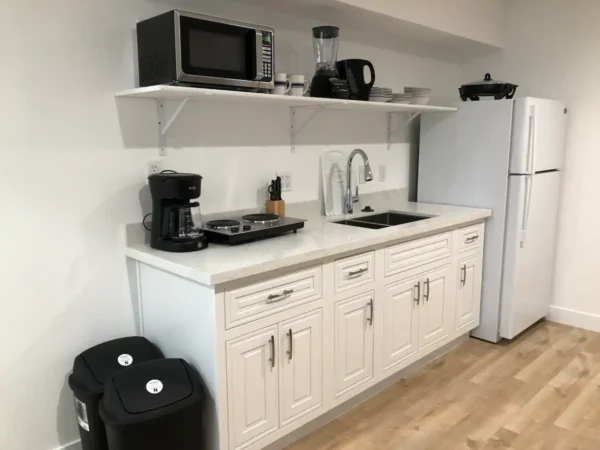 A kitchen with white cabinets and black appliances.