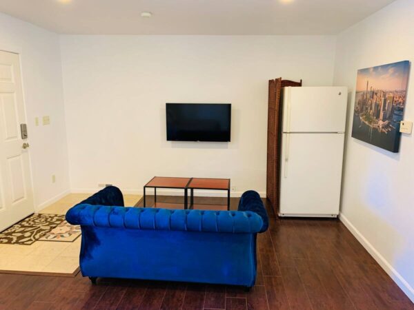 A living room with a couch, table and television.