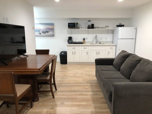 A living room with a couch, table and kitchen.