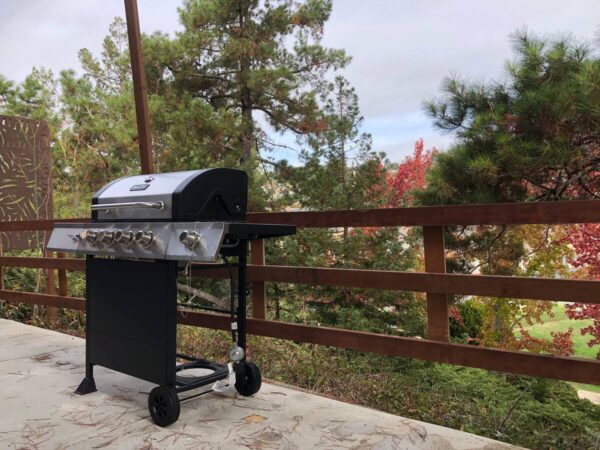 A grill on the patio of an outdoor house.