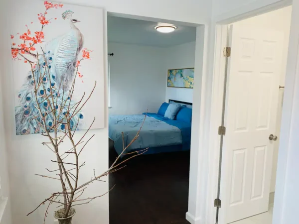 A bedroom with a bed and a vase of flowers.